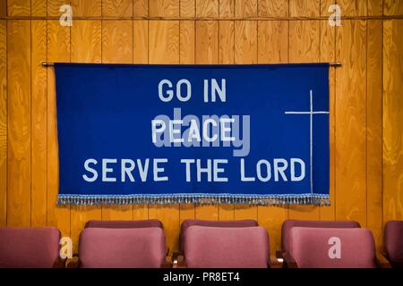 `Go in Peace Serve the Lord` written on Dark Blue Cloth with white cross on the right side, tassels all along the bottom of the cloth. Stock Vector